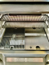 Load image into Gallery viewer, An image of the Que-Tensils Half Hot Plate for the Masterbuilt 560 sitting in the BBQ