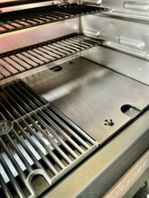 Load image into Gallery viewer, An image of the Que-Tensils Half Hot Plate for the Masterbuilt 560 sitting in the BBQ