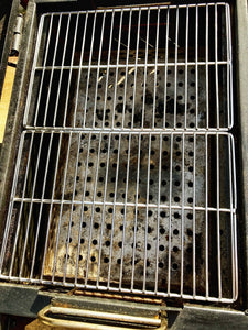 Two Que-Tensils Stainless Steel Half Grill Plates sitting in the Oklahoma Joe Rambler barbecue. 
